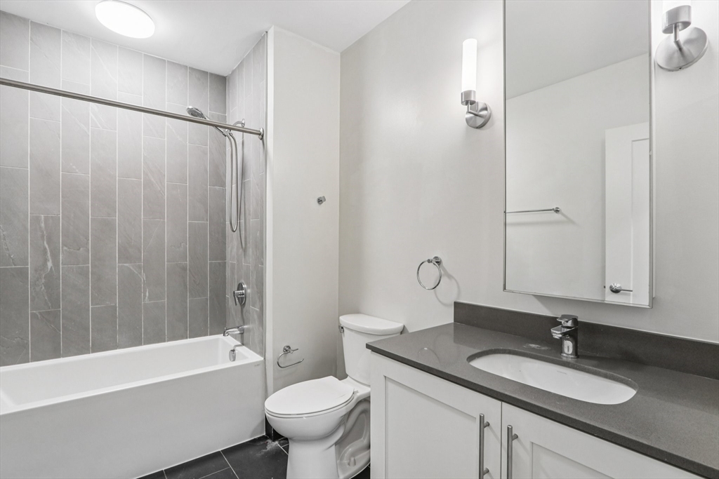 77 New Street, Unit 115 Cambridge, MA 02138 - Photo 5 of 11 a bathroom with a granite countertop sink toilet and shower