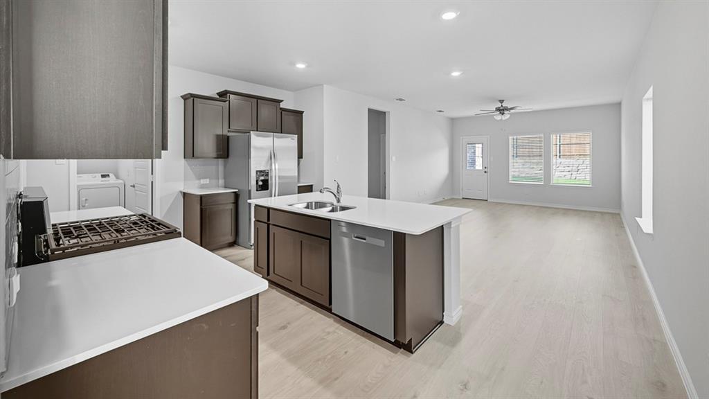 3421 Amaretto Road Aubrey, TX 76227 - Photo 23 of 38 a kitchen with a stove a sink and a refrigerator