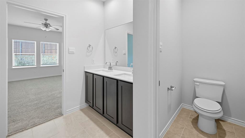 3421 Amaretto Road Aubrey, TX 76227 - Photo 3 of 38 a bathroom with a toilet a sink and mirror
