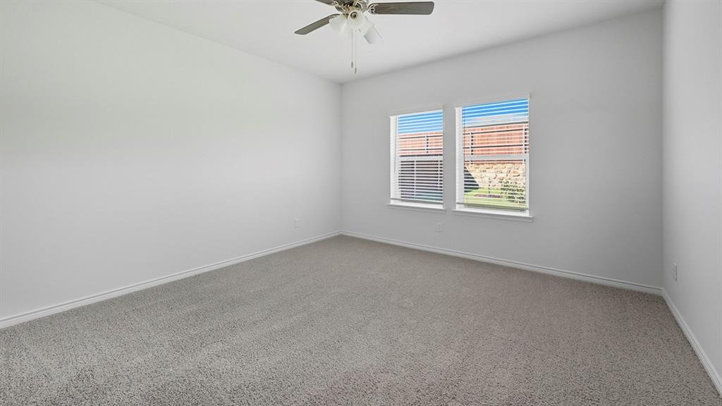 3421 Amaretto Road Aubrey, TX 76227 - Photo 8 of 38 an empty room with a chandelier fan and windows
