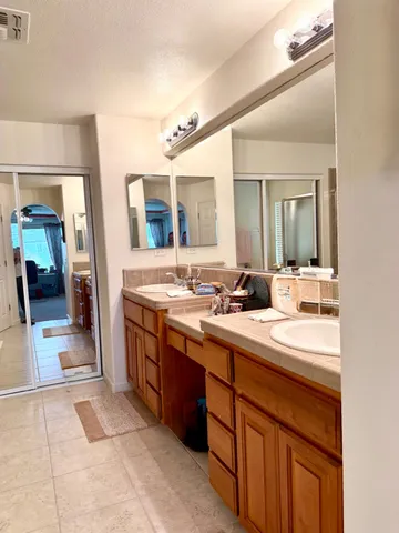 a spacious bathroom with a double vanity sink and a mirror