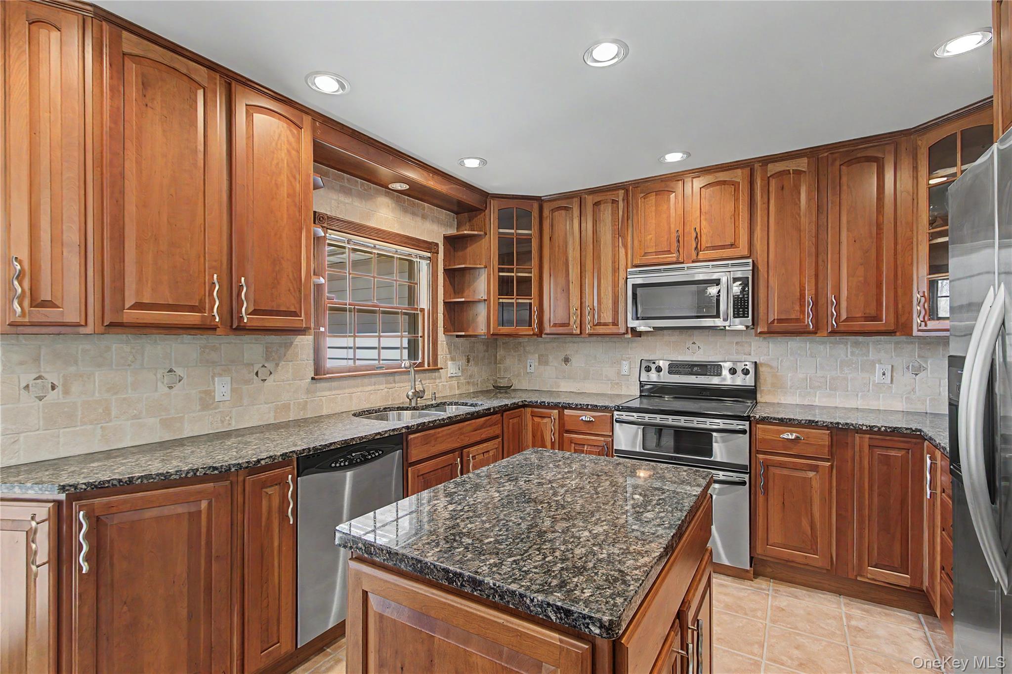 24 Richard Road Mahopac, NY 10541 - Photo 13 of 47 a kitchen with stainless steel appliances granite countertop wooden cabinets a stove top oven a sink and dishwasher
