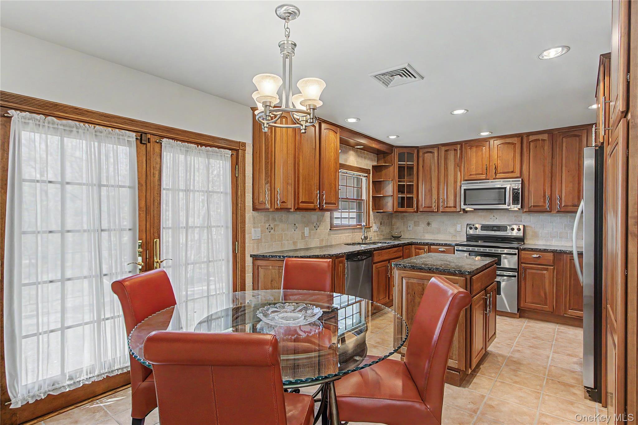 24 Richard Road Mahopac, NY 10541 - Photo 16 of 47 a kitchen with stainless steel appliances granite countertop a stove top oven a refrigerator a sink dishwasher a dining table and chairs with wooden floor