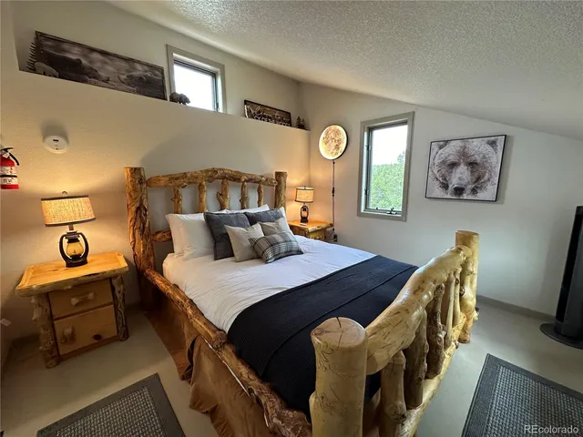 a bedroom with two beds and a potted plant on the dresser