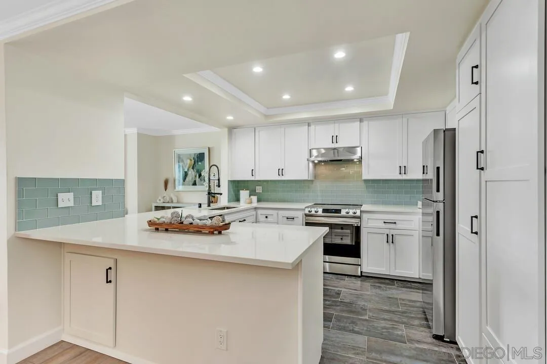 24 Montego Court Coronado, CA 92118 - Photo 11 of 71 a kitchen with white cabinets and stainless steel appliances