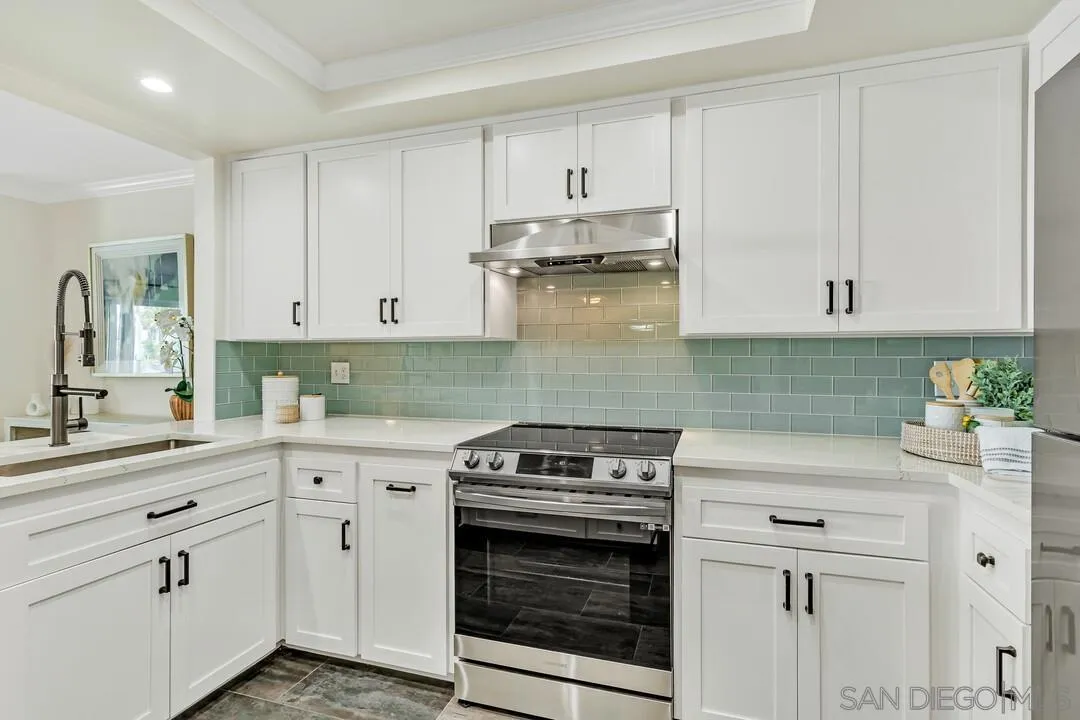 24 Montego Court Coronado, CA 92118 - Photo 14 of 71 a kitchen with granite countertop white cabinets and white appliances