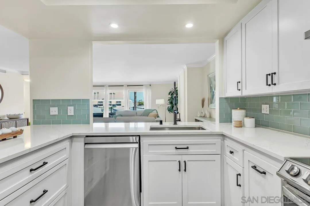 24 Montego Court Coronado, CA 92118 - Photo 19 of 71 a kitchen with kitchen island granite countertop a sink and white cabinets