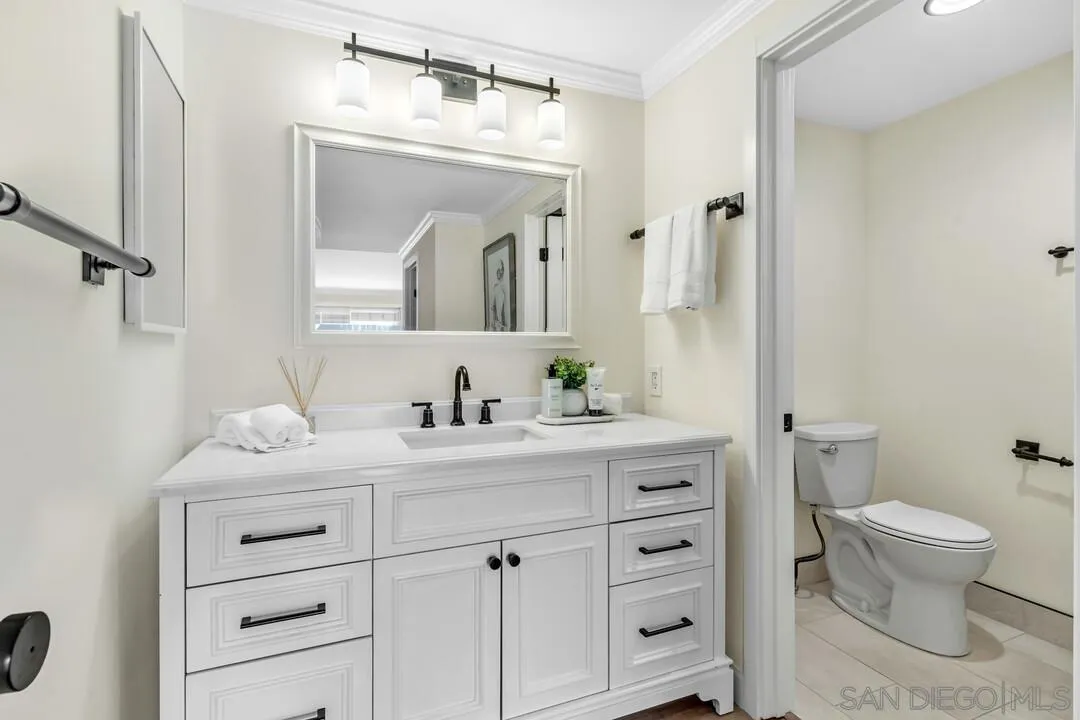24 Montego Court Coronado, CA 92118 - Photo 32 of 71 a bathroom with a granite countertop sink vanity mirror and toilet