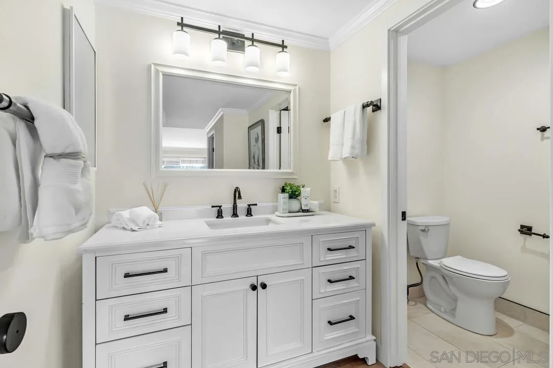 24 Montego Court Coronado, CA 92118 - Photo 33 of 71 a bathroom with a granite countertop sink vanity mirror and toilet