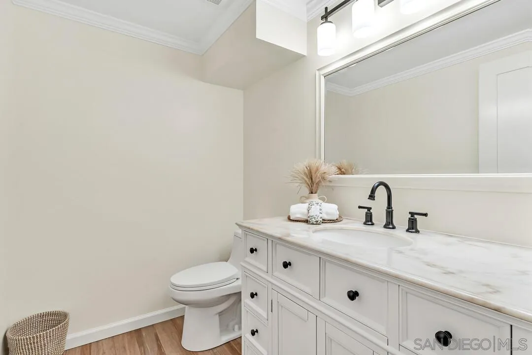 24 Montego Court Coronado, CA 92118 - Photo 36 of 71 a bathroom with a granite countertop toilet sink and mirror