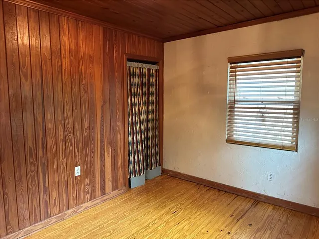 a view of a room with a wooden door and a window