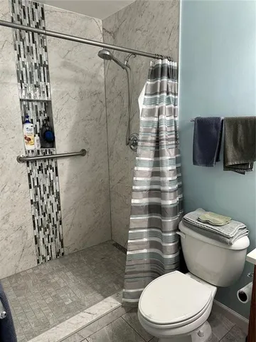 a white toilet sitting next to a shower curtain