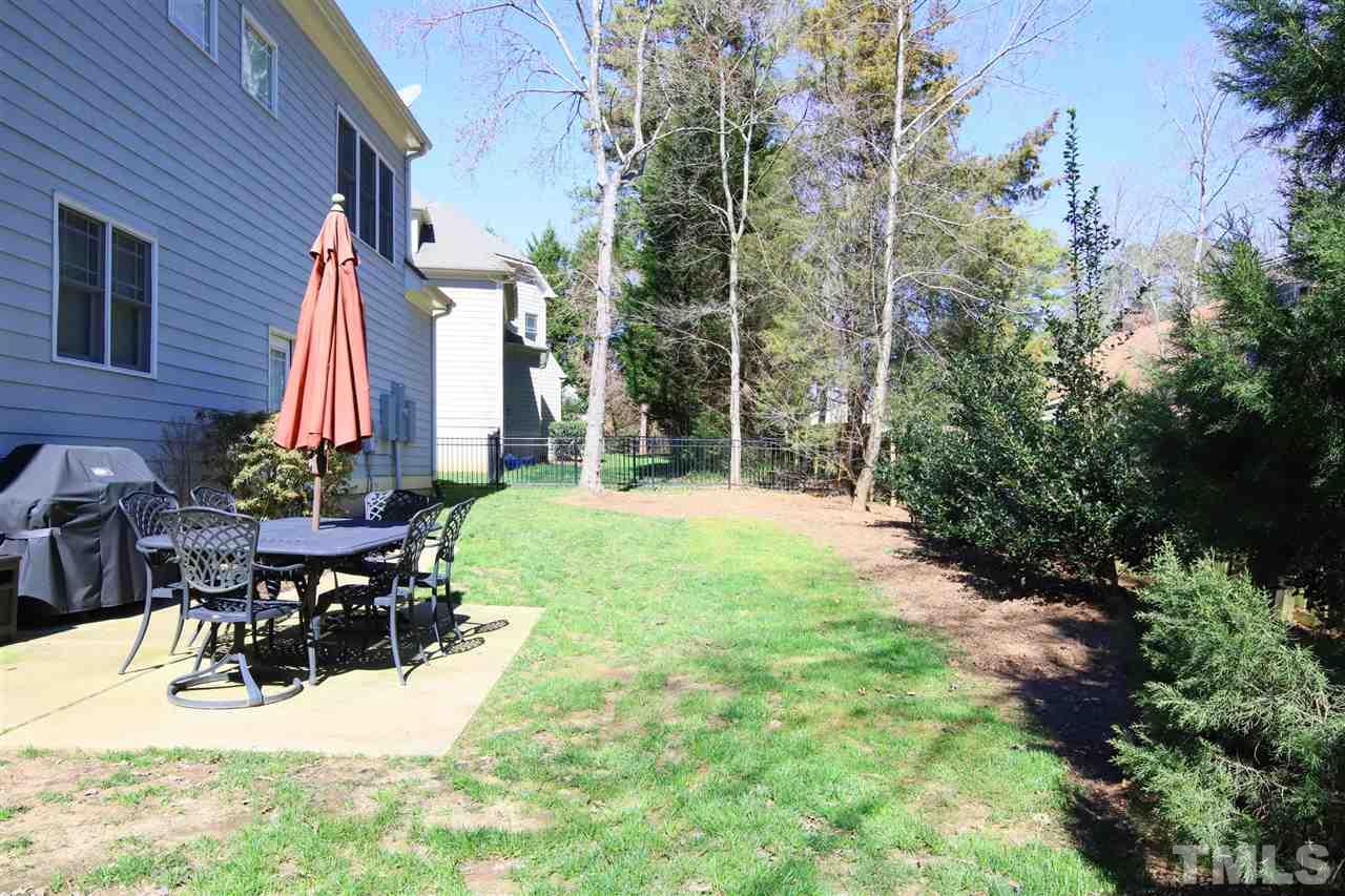 5706 Belmont Valley Court Raleigh, NC 27612 - Photo 3 of 6 a view of a patio with table and chairs potted plants and large tree