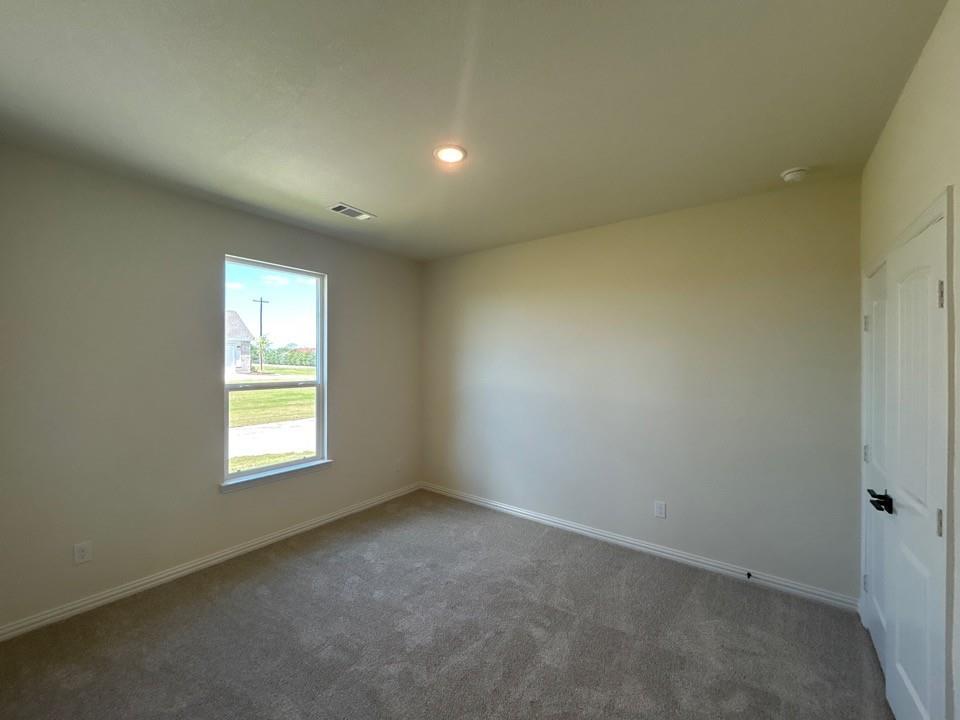 8813 County Road 623 Blue Ridge, TX 75424 - Photo 13 of 19 Carpeted room featuring a single window, recessed lighting, and a white paneled door with a black handle