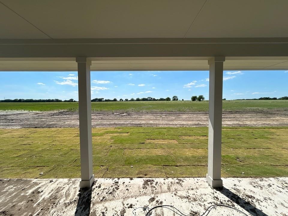 8813 County Road 623 Blue Ridge, TX 75424 - Photo 18 of 19 Covered patio with square support columns, offering expansive views of a partially sodded lawn and distant natural landscape