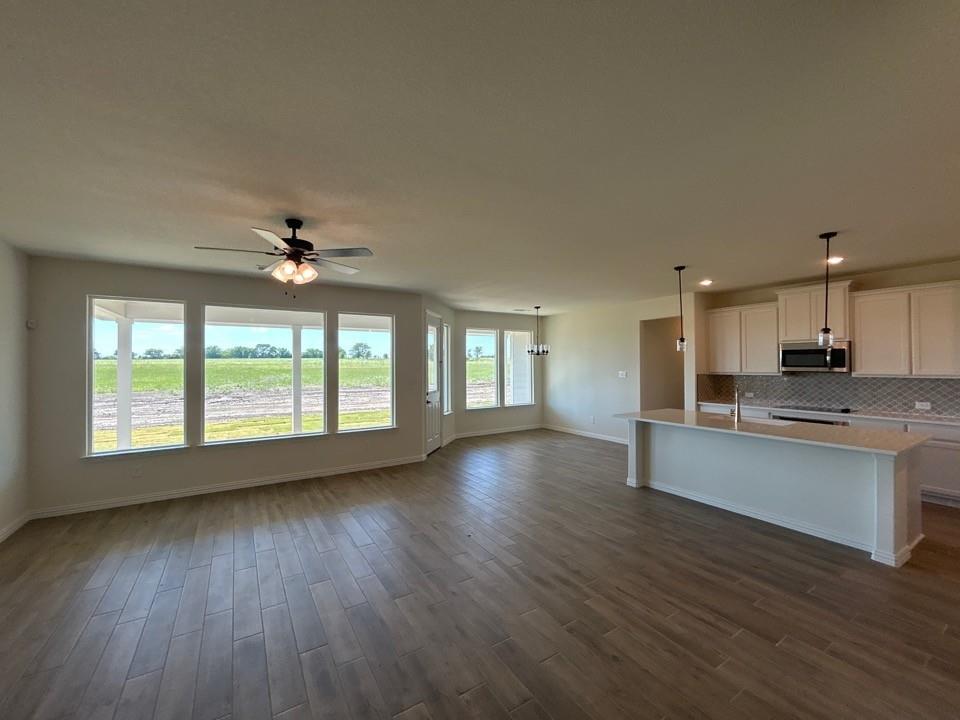 8813 County Road 623 Blue Ridge, TX 75424 - Photo 5 of 19 Open-concept living space featuring wood-finish flooring, a contemporary ceiling fan, and multiple large windows