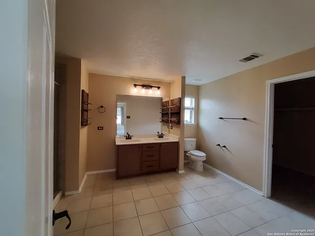 a large bathroom with a toilet a sink and mirror