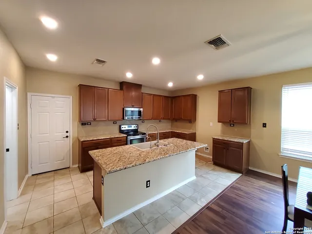 a large kitchen with kitchen island a sink stainless steel appliances and cabinets