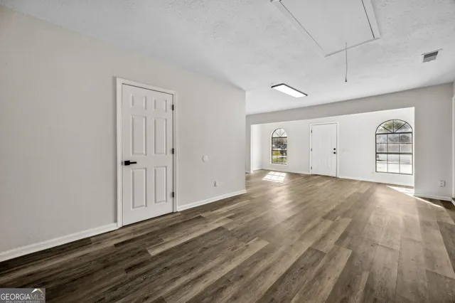 a view of empty room with wooden floor and ceiling fan