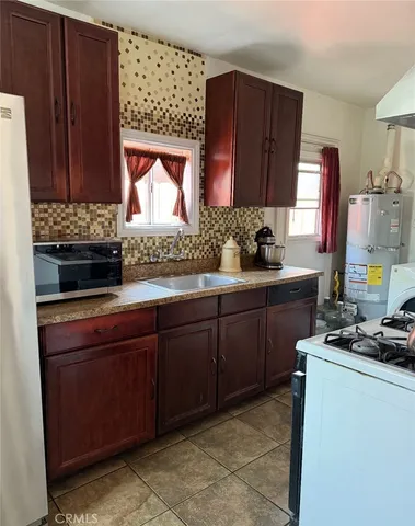 a kitchen with stainless steel appliances granite countertop wooden cabinets a stove and a sink