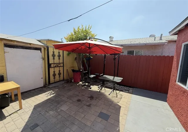 a view of a patio with table and chairs under an umbrella