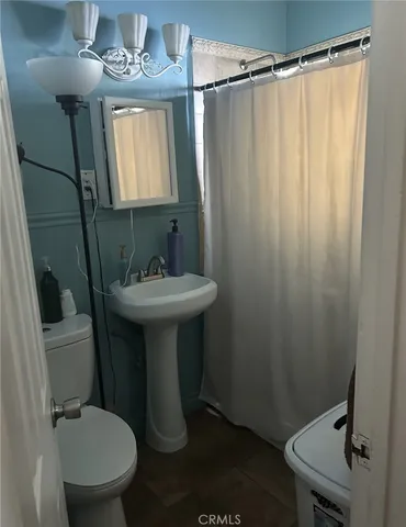 a bathroom with a sink mirror toilet and shower