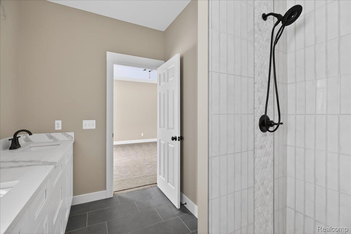 4050 Metamora Ridge Road Metamora, MI 48455 - Photo 43 of 65 Full bath featuring double vanity, walk in shower, and dark tile patterned flooring