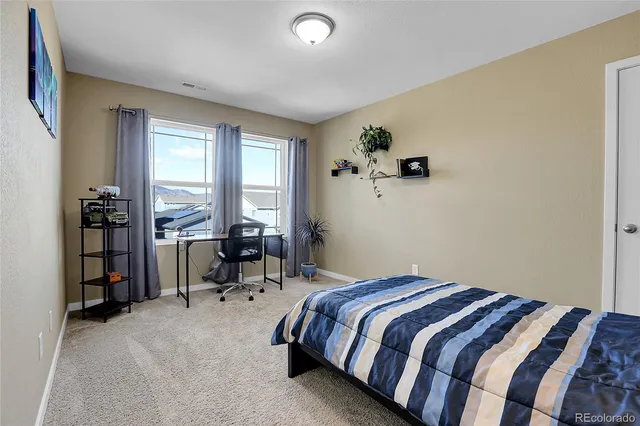 a bedroom with a bed and a potted plant