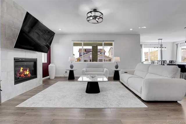 a living room with furniture a fireplace and a flat screen tv