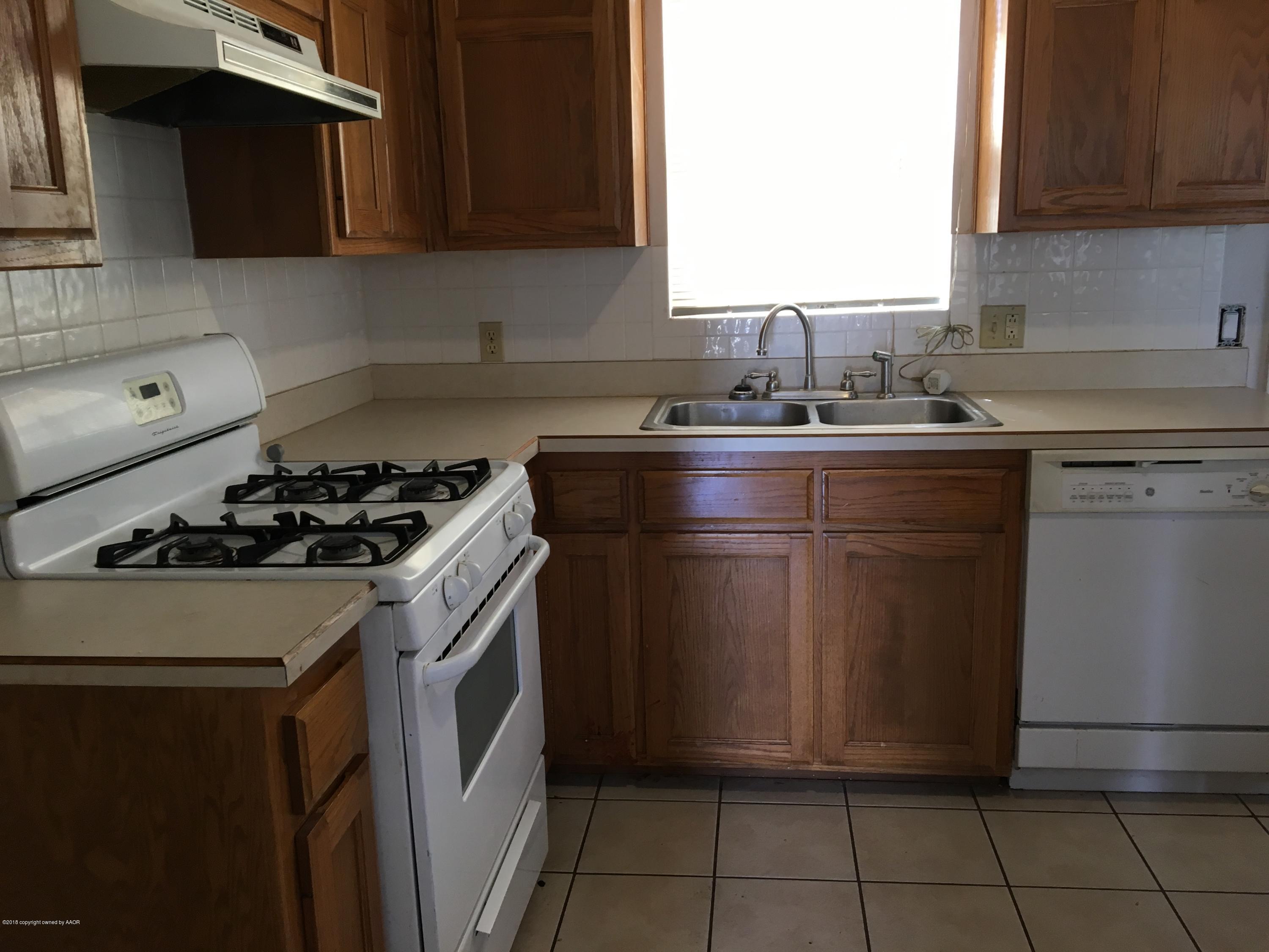 3800 South Tyler Street Amarillo, TX 79110 - Photo 5 of 5 a kitchen with a sink stove top oven and cabinets