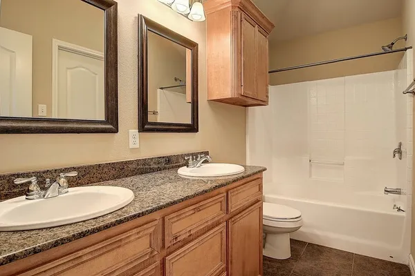a bathroom with a granite countertop sink toilet and a mirror