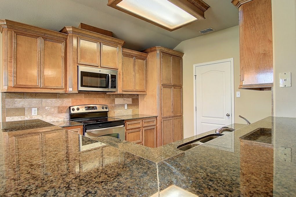 6824 Fox Tail Drive Corpus Christi, TX 78413 - Photo 3 of 40 a kitchen with stainless steel appliances granite countertop a stove a sink and a microwave