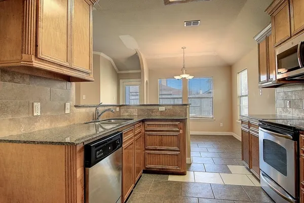 a kitchen with stainless steel appliances granite countertop a sink stove and cabinets