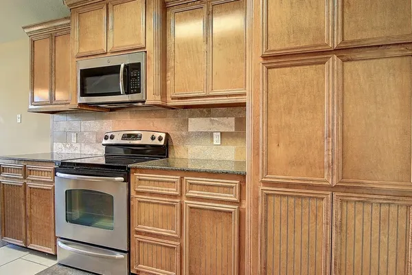 a kitchen with granite countertop stainless steel appliances and cabinets