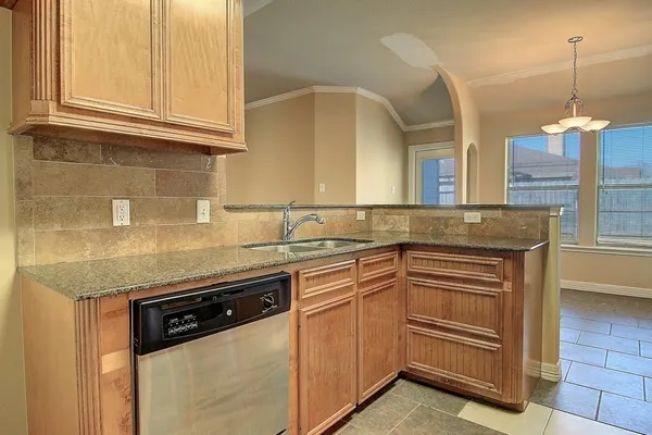 a kitchen with granite countertop a sink and cabinets