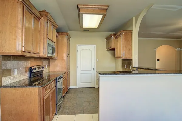 a kitchen with stainless steel appliances granite countertop a sink and a stove