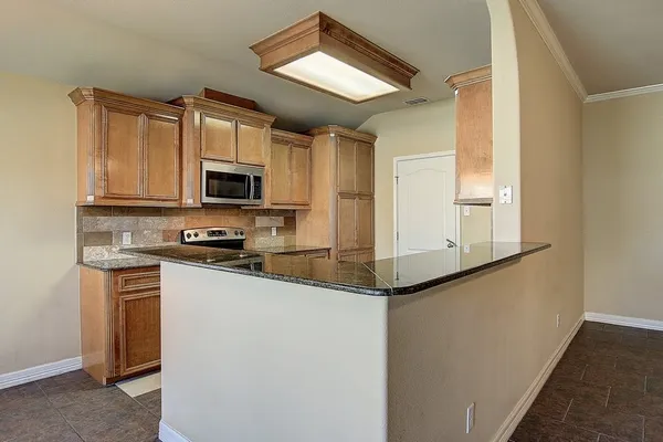 a kitchen with stainless steel appliances granite countertop a refrigerator a stove top oven a sink and dishwasher