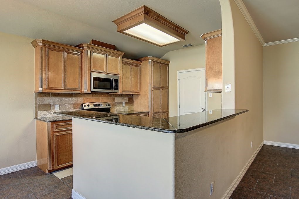 6824 Fox Tail Drive Corpus Christi, TX 78413 - Photo 9 of 40 a kitchen with stainless steel appliances granite countertop a refrigerator a stove top oven a sink and dishwasher