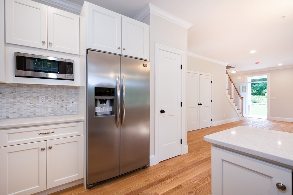 95 First Parish Road, Unit 1 Scituate, MA 02066 - Photo 11 of 24 a kitchen with stainless steel appliances a refrigerator sink and microwave