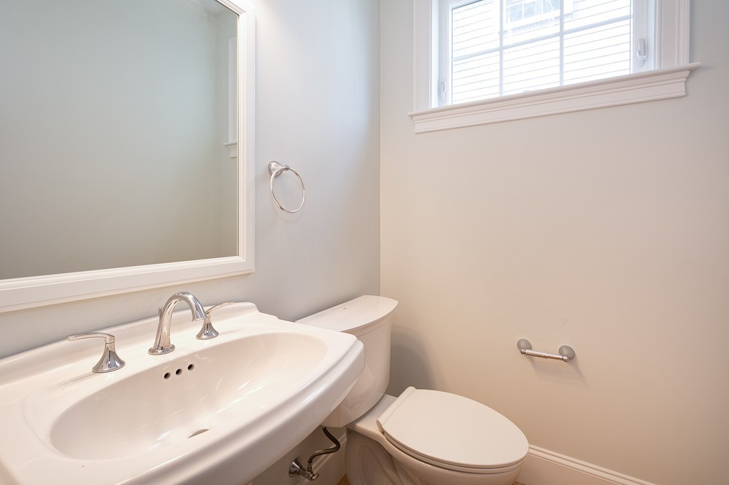 95 First Parish Road, Unit 1 Scituate, MA 02066 - Photo 13 of 24 a bathroom with a sink a toilet and a mirror