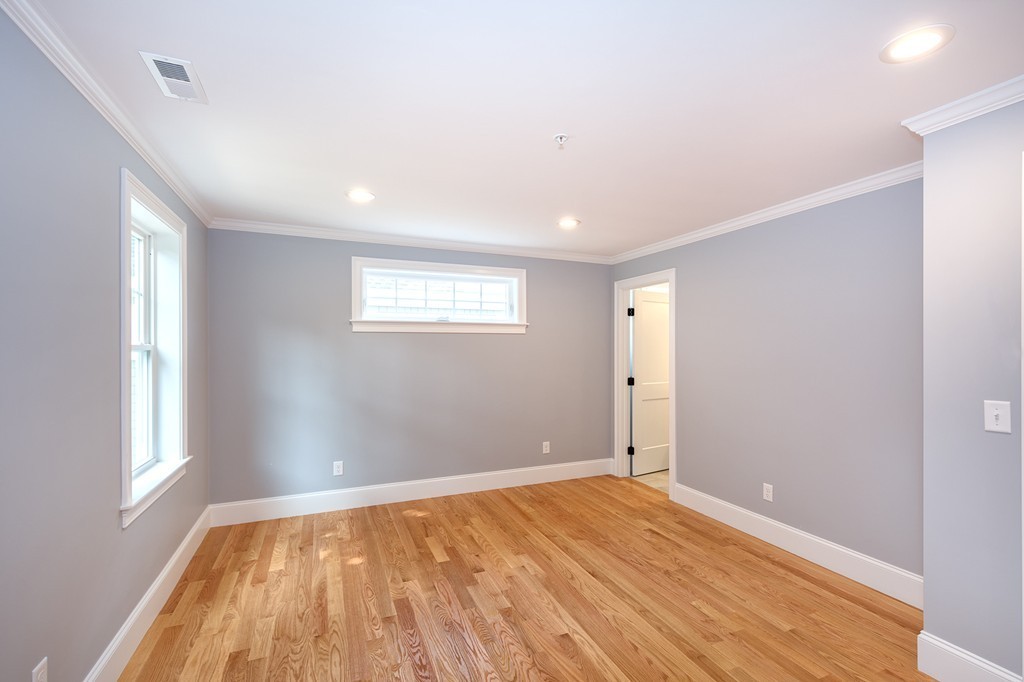 95 First Parish Road, Unit 1 Scituate, MA 02066 - Photo 21 of 24 a view of an empty room with wooden floor and a window