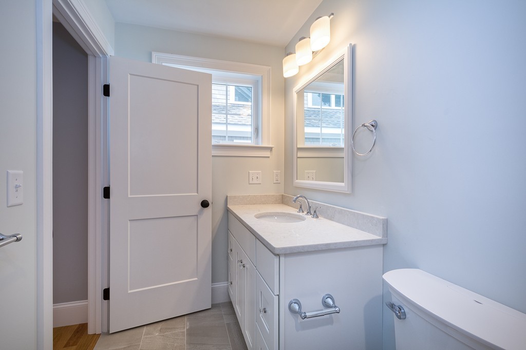 95 First Parish Road, Unit 1 Scituate, MA 02066 - Photo 23 of 24 a bathroom with a sink toilet vanity and window