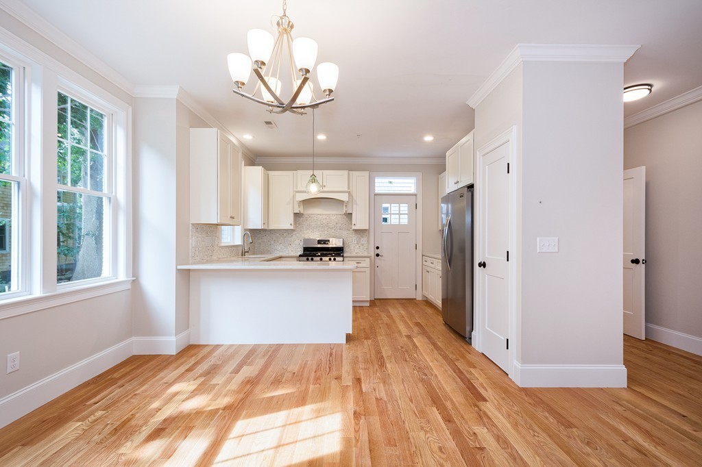 95 First Parish Road, Unit 1 Scituate, MA 02066 - Photo 9 of 24 a view of a kitchen with kitchen island wooden floor center island and stainless steel appliances