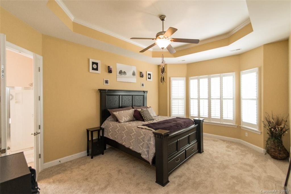 938 Treasure Court Fort Mill, SC 29708 - Photo 12 of 24 a spacious bedroom with a bed and a chandelier