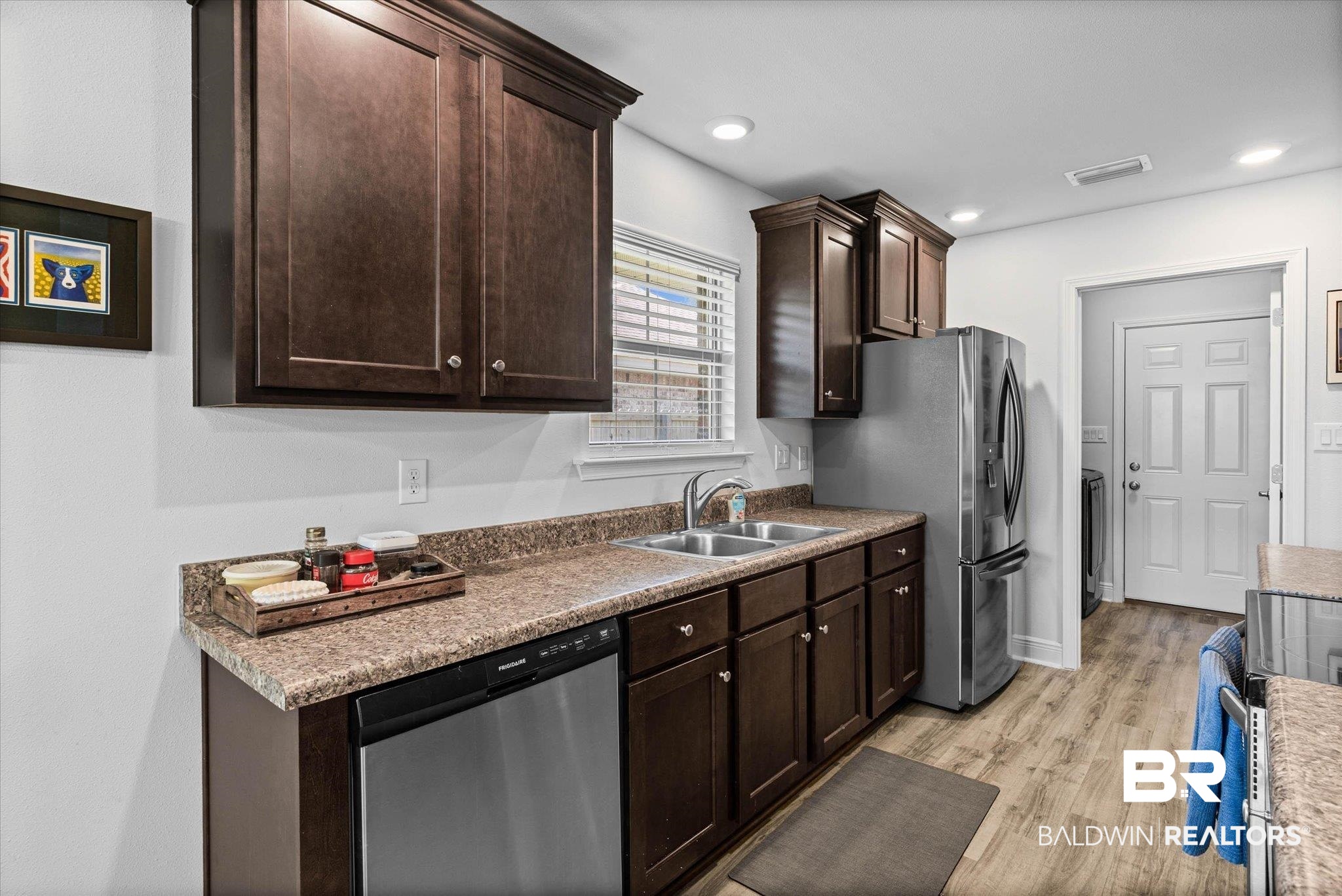 22420 Respite Lane Foley, AL 36535 - Photo 6 of 35 Kitchen featuring dark wood cabinetry, a double basin stainless steel sink, stainless steel dishwasher, and stone-finish countertops