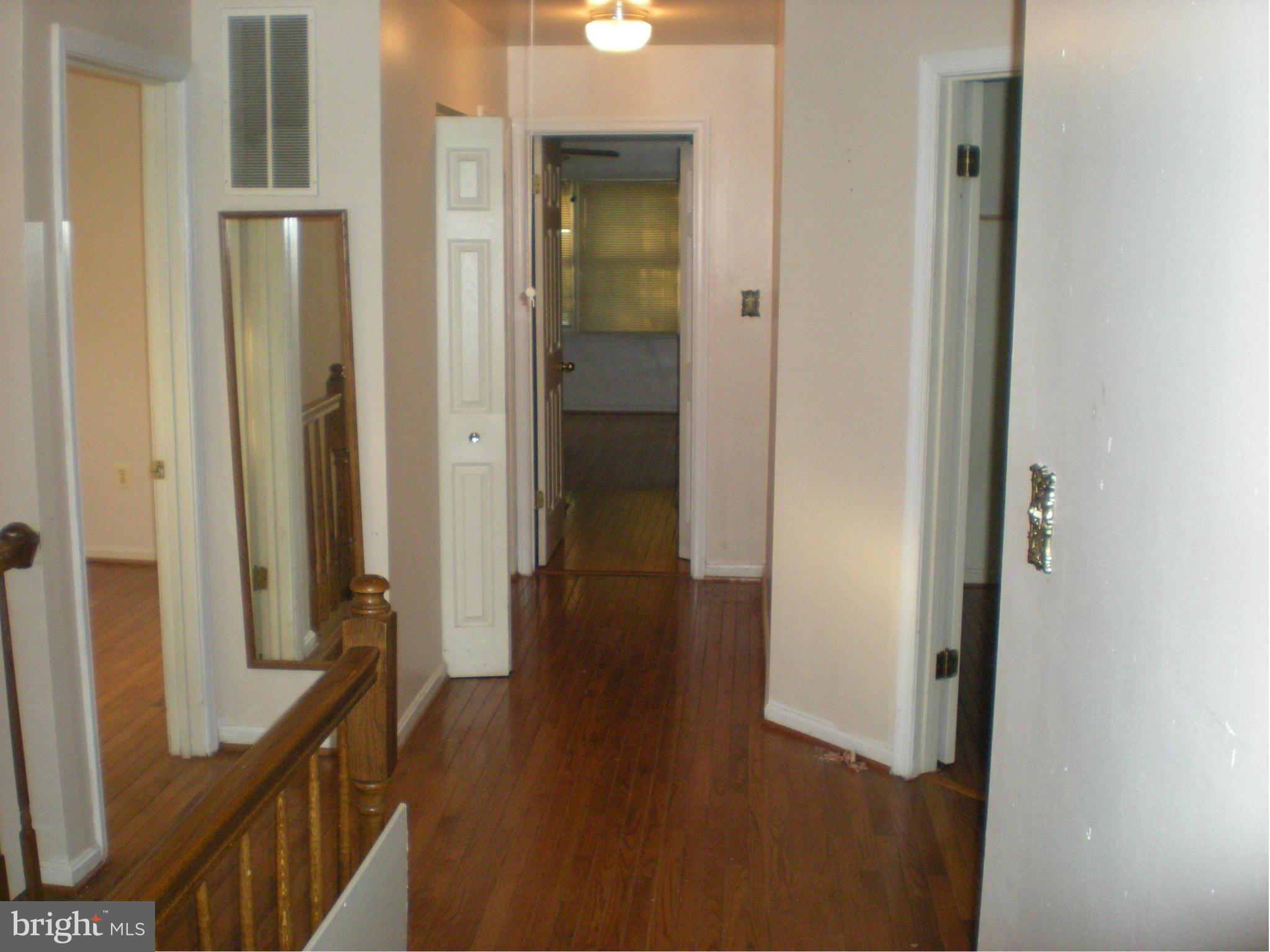 10812 Golf Course Terrace Bowie, MD 20721 - Photo 11 of 14 a view of a hallway with wooden floor and staircase