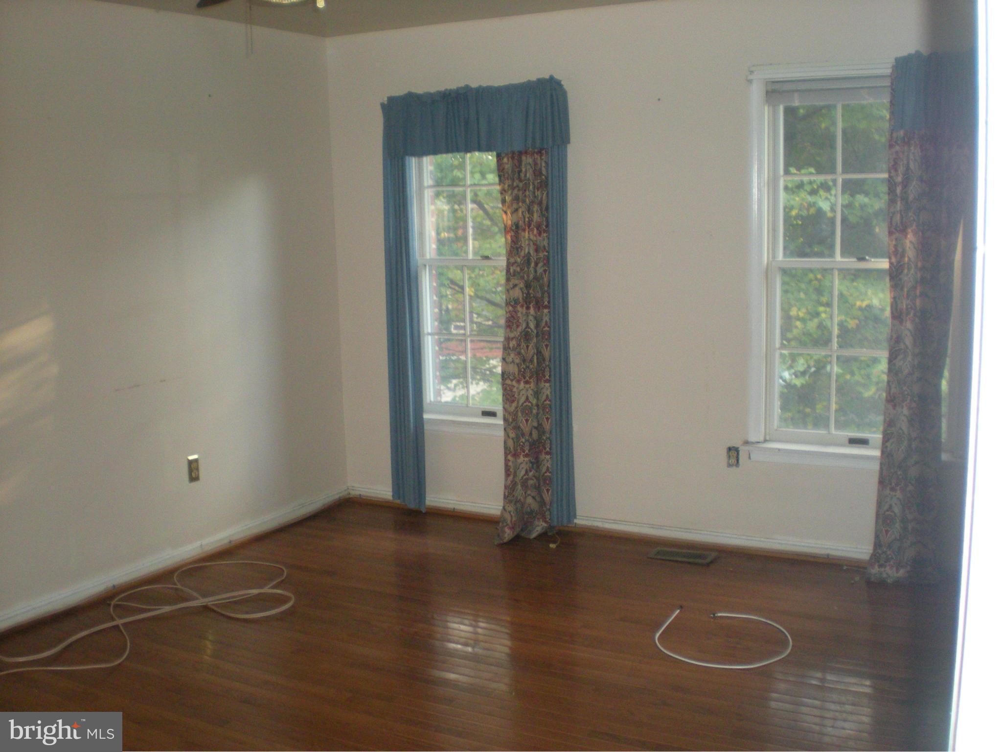 10812 Golf Course Terrace Bowie, MD 20721 - Photo 12 of 14 an empty room with wooden floor and windows