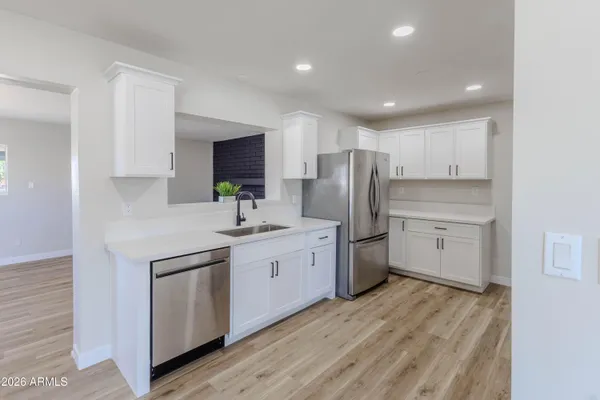 a kitchen with white cabinets stainless steel appliances and sink