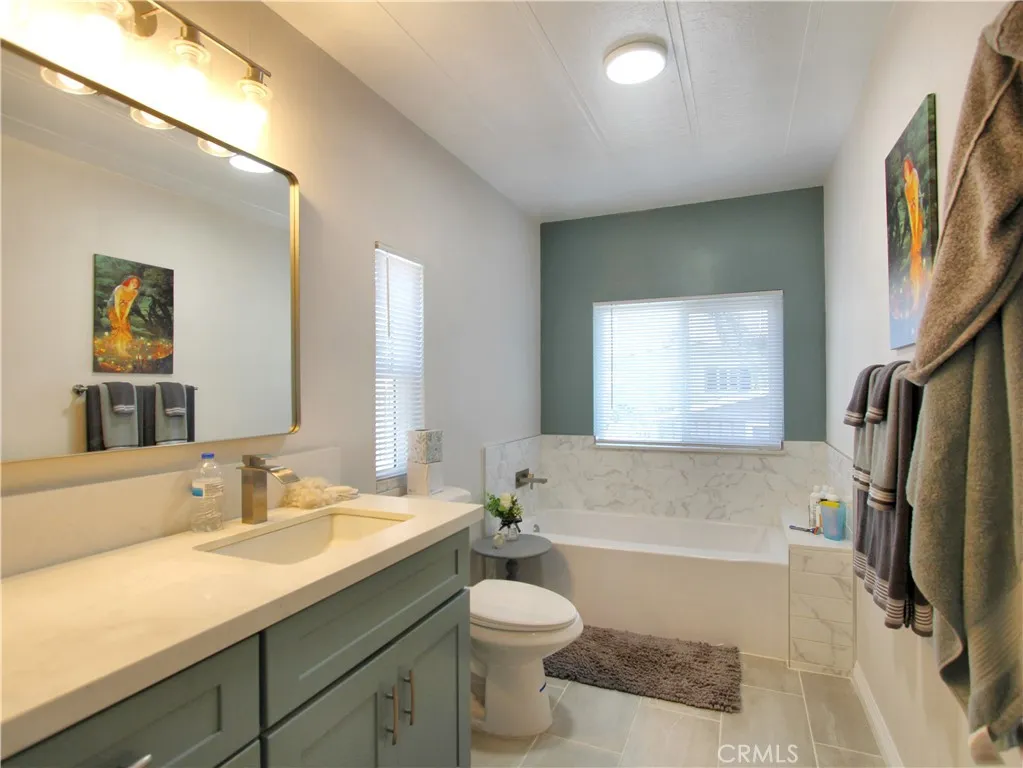 692 North Adele Street, Unit 101 Orange, CA 92867 - Photo 19 of 20 a bathroom with a granite countertop sink toilet and shower