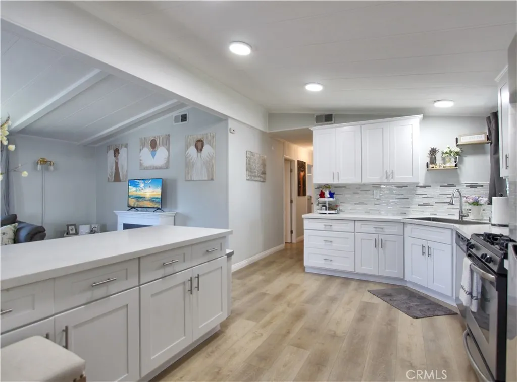692 North Adele Street, Unit 101 Orange, CA 92867 - Photo 7 of 20 a kitchen with granite countertop cabinets sink and white stainless steel appliances
